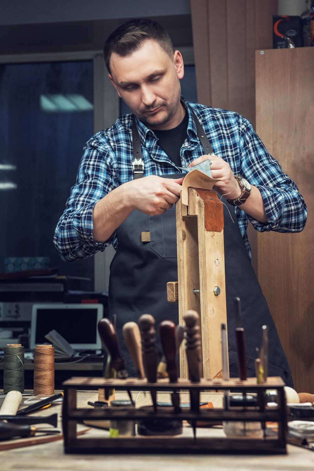 人缝合的皮革钱包在车间皮具手工工艺生产的概念皮具手工工艺生产的概念